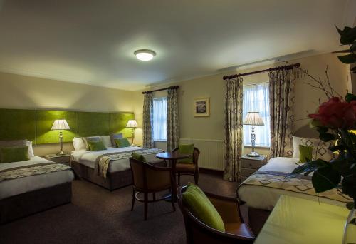 a hotel room with two beds and a table and chairs at Breffni Arms Hotel in Arvagh
