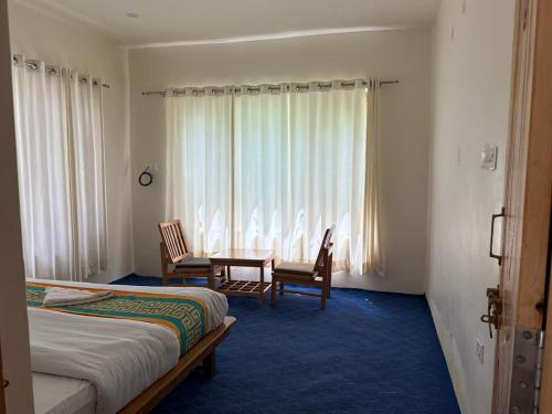 a hotel room with two beds and a table and chairs at De Khar Guest House in Leh