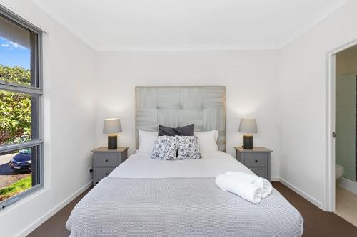 a bedroom with a large white bed with two lamps at 134 North Perth Nest for 4 parking in Perth