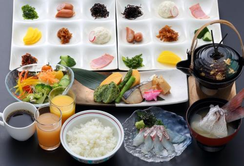 a table topped with plates of food and drinks at Kokuminshukusha Shodoshima in Shodoshima
