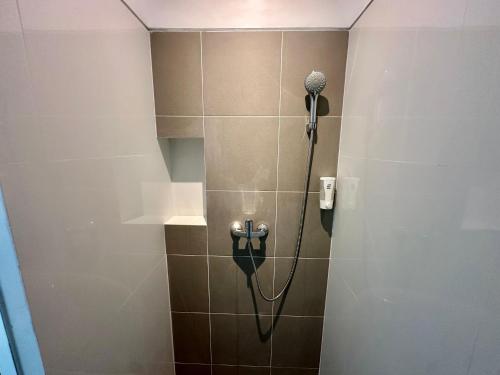 a shower with a blow dryer in a bathroom at The Pudina Stay Probolinggo 