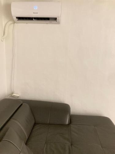a living room with a couch and a tv on a wall at Accommodation near Yeongil University in Pohang
