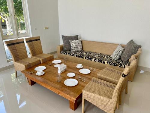 a living room with a couch and a table and chairs at The Pudina Stay Probolinggo 