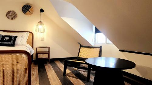 a bedroom with a bed and a table and a chair at Soho House Old Town Bangkok in Bangkok