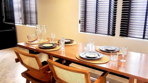 a wooden table with plates and glasses on it at Soho House Old Town Bangkok in Bangkok
