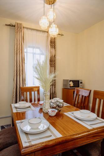 a dining room with a wooden table with chairs at Great Hornbill Holiday Home in Thika