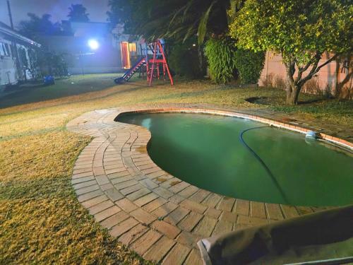 a small pool of water in a yard at night at Work Relax Celebrate Together in Edenvale