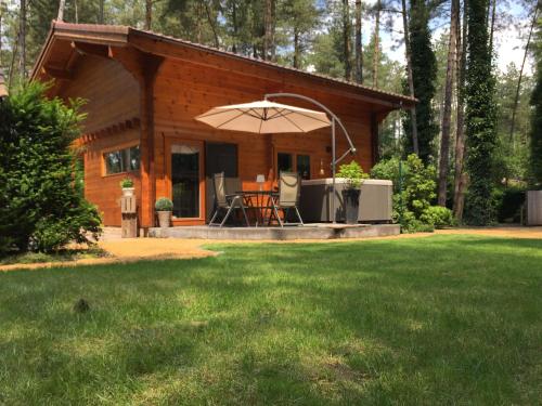 a small cabin with an umbrella in a yard at Casa Delux in Lille