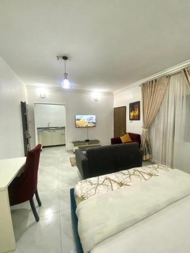 a living room with a bed and a couch at Studio Rooms Gudu in Abuja
