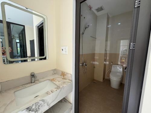 a bathroom with a tub and a toilet and a mirror at M&M homestay vincom Quang Tri in Quang Tri