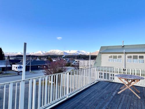 een houten terras met een tafel bovenop een huis bij Sunnyview - Lake Tekapo in Lake Tekapo