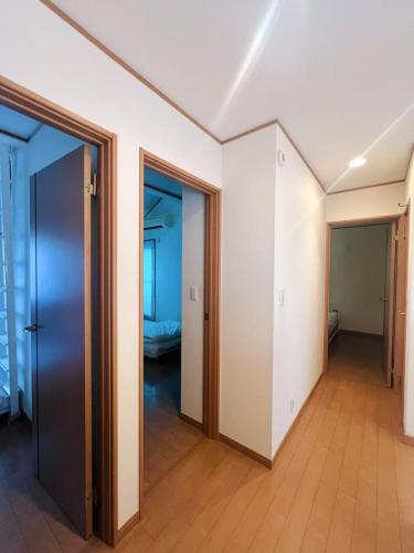 an empty room with two doors and a room with a bedroom at スペース海浜幕張ハウス in Chiba