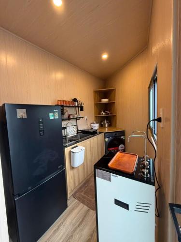 a kitchen with a black refrigerator and a counter at Hoàng Gia Villa in Ninh Hải