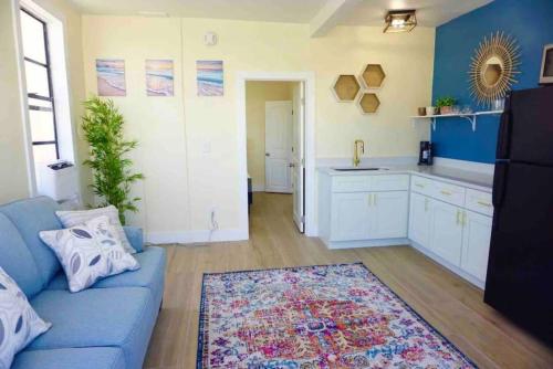 a living room with a blue couch and a kitchen at PETS OK Steps 2 Ocean Center Walk 2 Beach in Daytona Beach