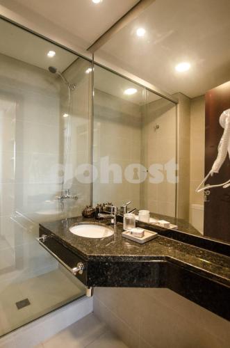 a bathroom with a sink and a large mirror at Cozy Villa Morra Apt in Asunción