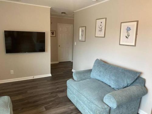a living room with a blue couch and a flat screen tv at 3 Bedroom Cozy Home Minutes From Tims Ford Lake in Winchester