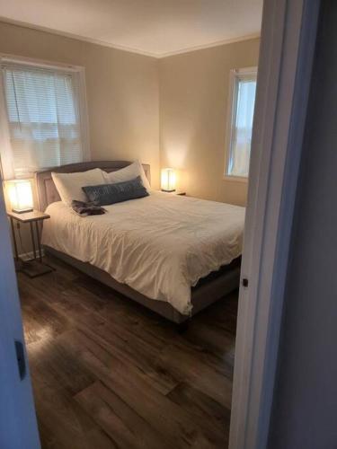 a bedroom with a bed with two windows and two lamps at 3 Bedroom Cozy Home Minutes From Tims Ford Lake in Winchester