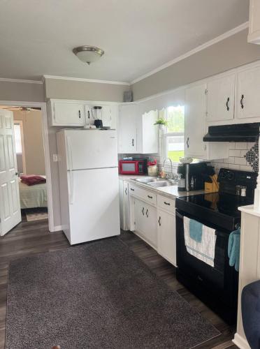 a kitchen with white cabinets and a white refrigerator at Newly Renovated Cozy Place Minutes From The Lake in Winchester
