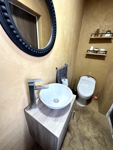 a bathroom with a sink and a toilet and a mirror at Best location in Oaxaca in Oaxaca City