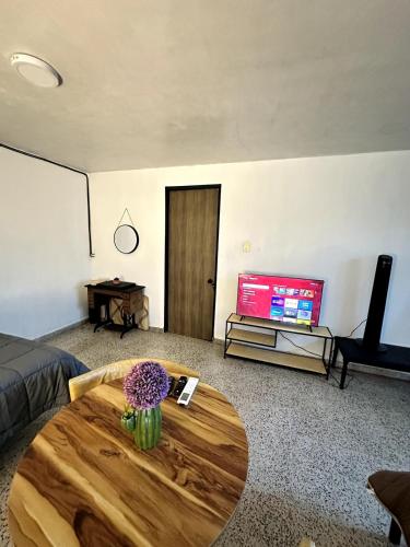 a living room with a table and a tv at Best location in Oaxaca in Oaxaca City