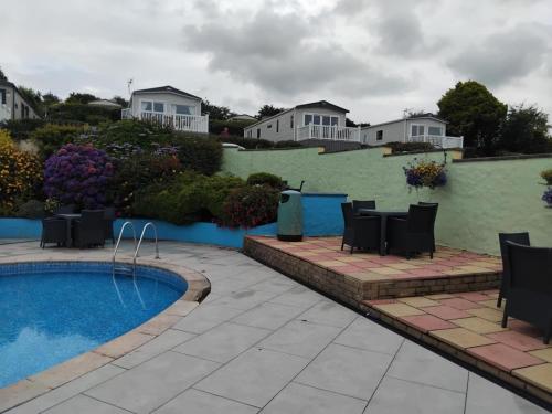 a patio with chairs next to a swimming pool at Caravan 26 fishguard holiday park in Fishguard