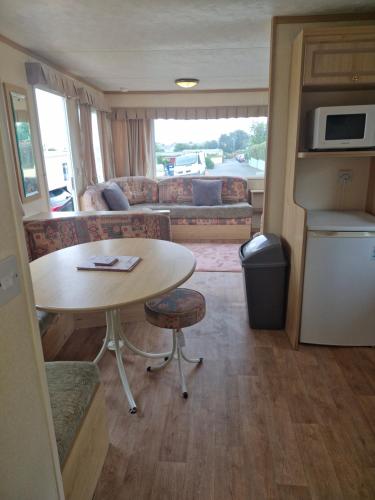 a living room with a table and a couch at Caravan 26 fishguard holiday park in Fishguard