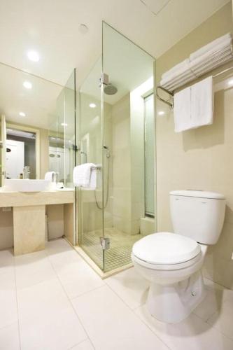 a bathroom with a toilet and a shower and a sink at Jinjiang Metropolo Hotel Classiq YMCA People Square in Shanghai