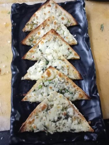 a black plate with a group of pizza slices at Arambol Residensea in Pernem