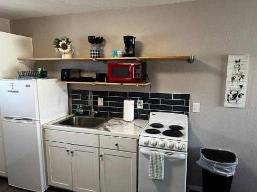 a kitchen with a sink and a white refrigerator at 1 Bedroom Wbalcony Near Unm, Nob Hill Downtown in Albuquerque