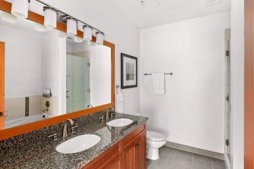 a bathroom with two sinks and a toilet and a mirror at Elevated Alpine Escape Premium Snowmass Luxury in Snowmass Village