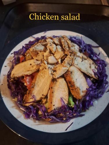 a plate of food with chicken salad and purple cabbage at Arambol Residensea in Pernem