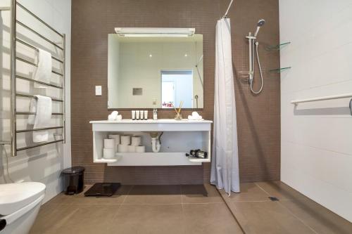 a bathroom with a sink and a mirror at Shelley Beach Homestead in Waiheke Island