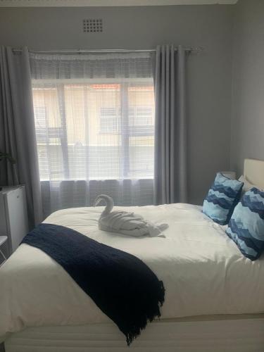 a swan on a bed in a bedroom with a window at Maita Guest in Cape Town