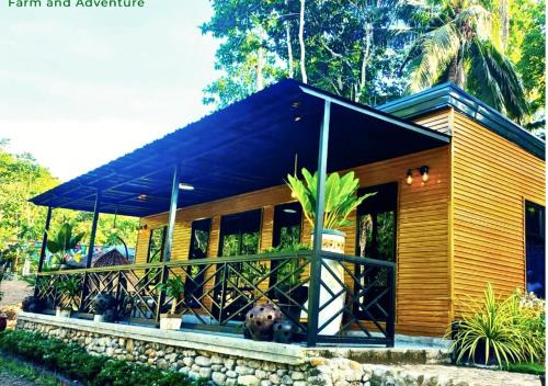 a small wooden house with a black roof at Daya Farm and Adventure in Banay-Banay