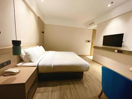 a hotel room with a bed and a television at City Comfort Inn Wuhan Wansongyuan Wangjiadun East Metro in Wuhan