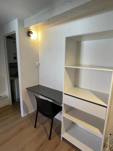 Studio centre ville في بيزنسون: غرفة بها مكتب ورف كتب