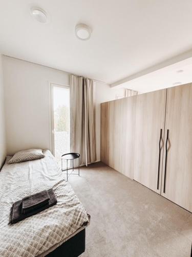 1 dormitorio con cama, armarios y ventana en Neliailpila Triangle, en Kokkola