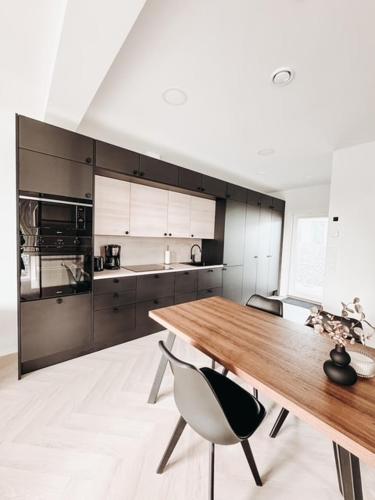 Una cocina con una mesa de madera y dos sillas. en Neliailpila Triangle, en Kokkola