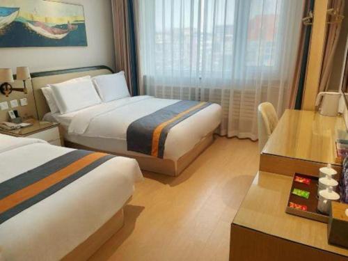 a hotel room with two beds and a desk at Beijing Inner Mongolia Hotel Chaoyang in Beijing