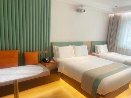 two beds in a hotel room with green curtains at Beijing Inner Mongolia Hotel Chaoyang in Beijing