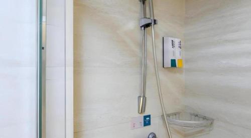 a shower in a bathroom with a glass door at City Comfort Inn Wuhan Hankou Railway Station West Square in Wuhan