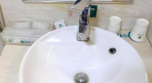 a white sink with a faucet on top of it at City Comfort Inn Wuhan Hankou Railway Station West Square in Wuhan