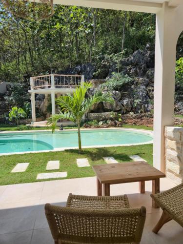 a patio with a table and chairs next to a pool at Summerforest Watukarung in Watukarung