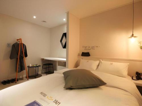 a bedroom with a bed with a suit on a mannequin at Hotel Yam ANDONG in Andong