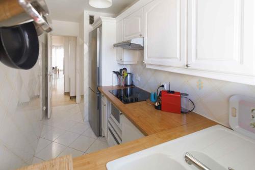 une cuisine avec des armoires blanches et un appareil rouge dans l'établissement One-bedroom apartment near the Beach and the Old Town, à Antibes