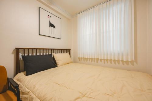 a bedroom with a bed and a window at Wooden Breeze - 1 min walk from the subway station in Seoul