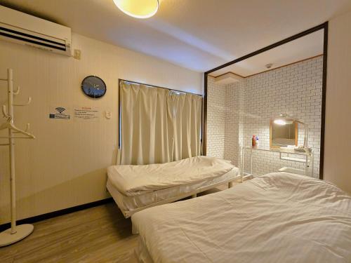 a hospital room with two beds and a window at Comfort CUBE PHOENIX Beppu (やよいビル) in Beppu