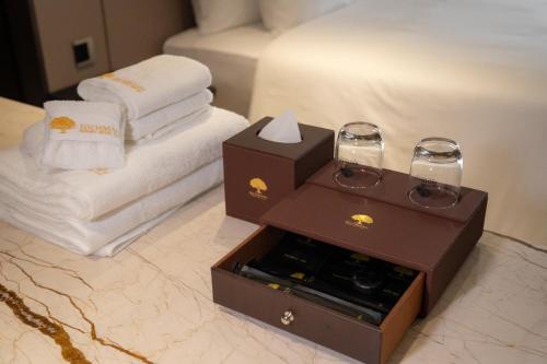 a hotel room with a bed and a box of wine glasses at Richmann Resort Hotel Hatyai in Hat Yai