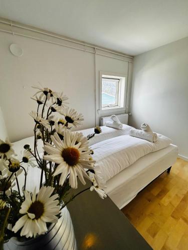 a bedroom with a bed with flowers in a vase at Ilulissat Stay - Siku in Ilulissat