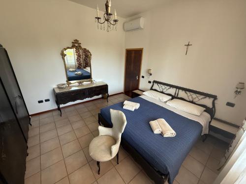 a bedroom with a bed and a chair and a mirror at Casa Cervi in Gabicce Mare